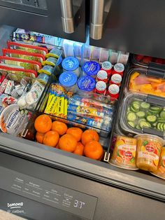 an open refrigerator filled with lots of different types of drinks and food in plastic containers