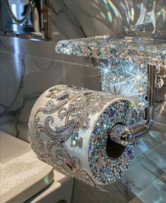 an elaborately decorated toilet paper roll holder with crystal beads on the top and sides