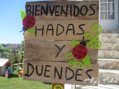 a wooden sign that says, benvendos hadas y duendes with ladybugs on it