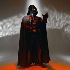 a darth vader standing in front of a white light with his hand up