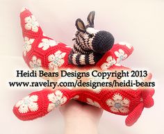 a hand holding two knitted stuffed animals on top of each other with the words hedi bears designs copyright 2013