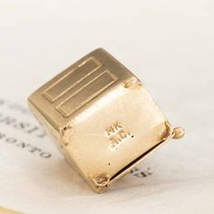 Into jewels (well, you must be, if you're here!)? Then you will instantly recognize this safe charm. And the best part? Its studded with a folder d dollar bill inside - how adorable is that? 14kt yellow gold 5.6 grams Measures: 13.44mm" L x 12mm W 14k Yellow Gold Jewelry With Certificate Of Authenticity, Gift Yellow Gold Jewelry With Maker's Mark, Yellow Gold Jewelry With Maker's Mark As Gift, Collectible 14k Gold Jewelry With Hallmarks, Rectangular 14k Gold Collectible Jewelry, Modern Mens Rings, Art Jewelry Earrings, Printable Ring Sizer, Bespoke Rings