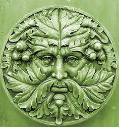 a green door with a face made out of leaves and acorns