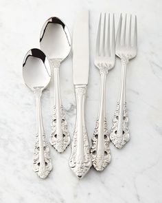 five silverware pieces on a marble surface