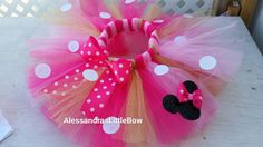 a minnie mouse tutu with polka dots and a pink bow on it's head