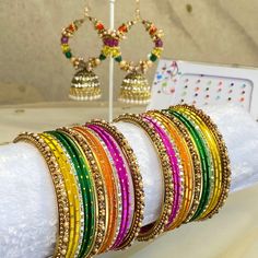 The perfect gift for Mehndi, Eid or special occasion! This gift box contains bangle set, earring and bindi pack.  2 small half stacks of beautiful multicoloured  bangles with pearl detail.  See our bangle size chart, measured 1.5 inch length each arm.    Stunning lightweight jhumka hoop earrings 2.5 inch length x 1.75 inch wide A pack of small colourful bindis! Ready to ship! Multicolor Tilla Jewelry For Gifts, Fusion Style Bangle As Diwali Gift, Festive Adjustable Earrings For Gifts, Festive Gift Earrings, Fusion Style Cutdana Bangle As Gift, Adjustable Multicolor Bangle For Diwali, Multicolor Cutdana Bracelets As Gifts, Fusion Style Bangle For Festival Celebrations, Fusion Style Bangle For Celebrations And Festivals