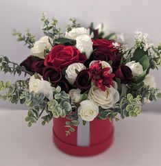 a red and white flower arrangement in a red box