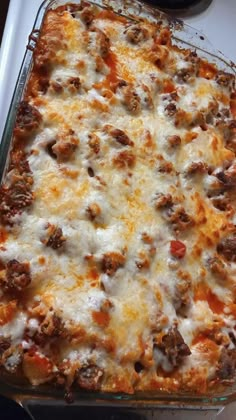 a casserole dish with meat and cheese in it sitting on a stove top