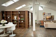 a living room filled with white furniture and lots of bookshelves on top of it