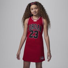 This dress, designed in the style of the jersey Michael Jordan wore during his storied basketball career, is made of breathable mesh fabric. Additionally, it's easy to layer over bike shorts or leggings for full coverage thanks to the roomy A-line construction. Sporty Spring Activewear For Cheerleading, Cheerleading Sportswear For Sports Season, Casual Sports Dress With Moisture-wicking, Sporty Sleeveless Sports Dress, Sportswear For Cheerleading, Sporty Fitted Tops For Playwear, Red Activewear For Sports, Red Activewear For Sports In Spring Season, Red Activewear For Spring Sports