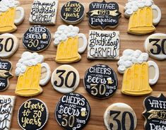 decorated cookies are arranged on a table with beer mugs and cheers written on them