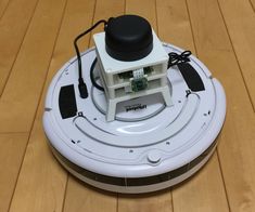 a robotic vacuum on the floor with its lid open