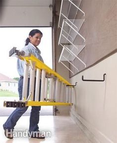 a woman walking up the side of a building with a ladder attached to her back