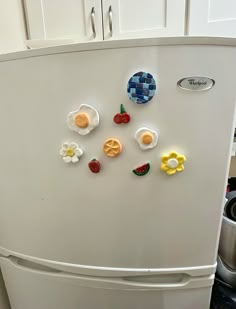 a white refrigerator with magnets on it in a kitchen