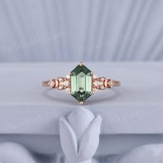 an emerald ring with three diamonds on it