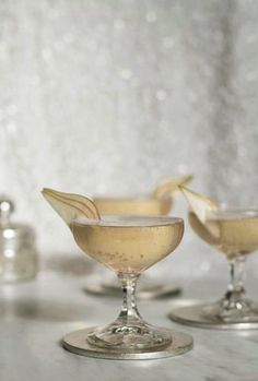 two martini glasses sitting on top of a counter