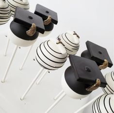 black and white graduation cake pops with gold tassels are on display in front of the camera