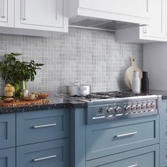 a stove top oven sitting inside of a kitchen next to blue cabinets and counter tops