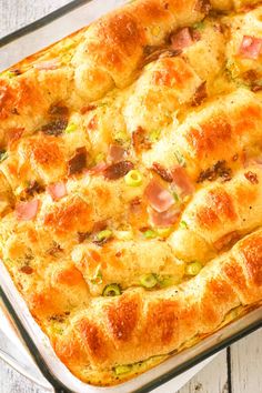 a casserole dish with ham and cheese in it on a white wooden table