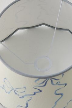 a white lamp shade with blue designs on it