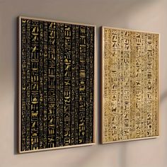 two paintings with egyptian writing on them hanging on the wall in an empty room next to each other