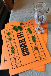 three game boards sitting on top of each other next to a jar of dices