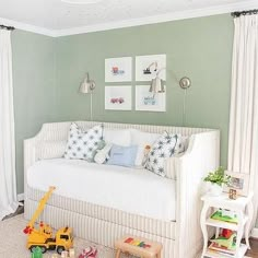 a child's bedroom with green walls and white furniture, including a daybed