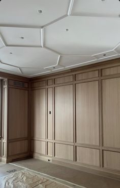 an empty room with wood paneling and white ceiling