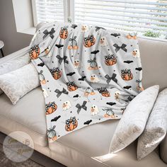 a couch covered in a blanket with pumpkins and bats on it