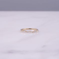 a white marble surface with a gold ring on it's side, and the top half