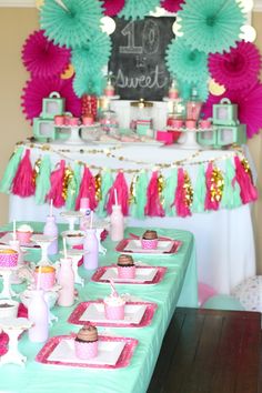 the table is set up with pink and green decorations