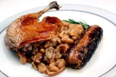 a white plate topped with meat and beans