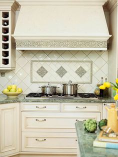 a kitchen with white cabinets and yellow flowers on the counter