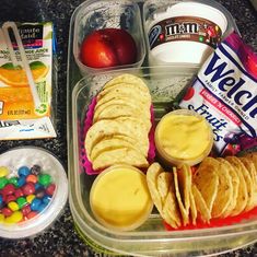 a plastic container filled with lots of food on top of a counter next to other items