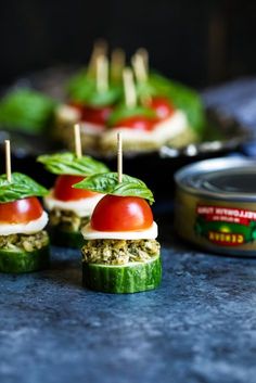 small appetizers with tomatoes, cucumbers and cheese on them are ready to be eaten