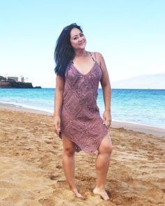 a woman standing on top of a sandy beach