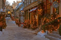 a snowy street lined with shops and decorated for christmas