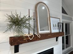 a fireplace mantle with a mirror and flowers on it