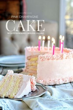 a slice of cake with pink frosting and lit candles