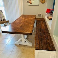 a wooden table sitting in the middle of a room next to a white door and window