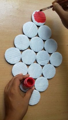 someone is painting circles on the table with red paint and paper machs to make it look like they have been made out of toilet paper