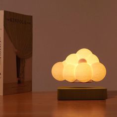 a cloud shaped lamp sitting on top of a wooden table