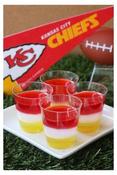 mini jello cups are sitting on a plate with a football in the back ground