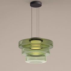 a green glass light hanging from a ceiling fixture with two lights on each side of it