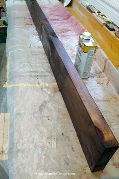 a piece of wood sitting on top of a table next to a can of paint