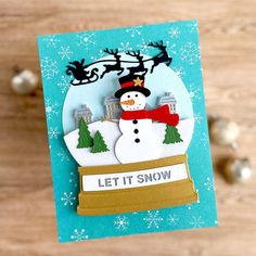 a christmas card with a snowman and reindeer on it, which says let it snow