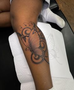 a woman's arm with a butterfly tattoo on the left side of her leg