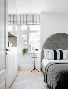 a bedroom with white walls and wood floors