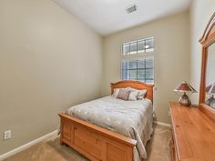 a bed sitting next to a window in a bedroom