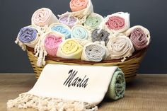 a basket filled with lots of different colored towels next to a towel on top of a table